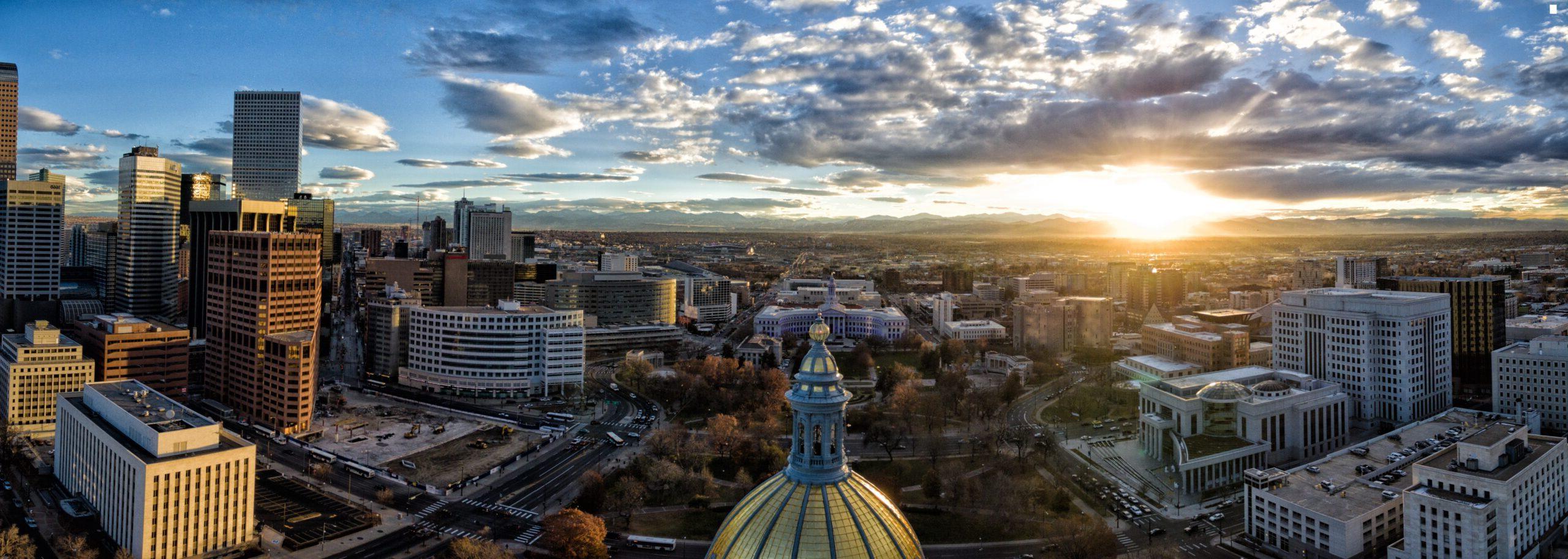 Beautiful drone photograph of a sunset over the golden cupola of the Colorado Capital building in the city of Denver